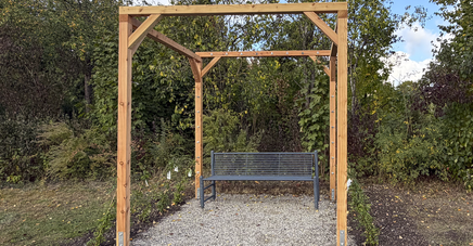 Pergola (Holzgestell) - darunter eine Parkbank