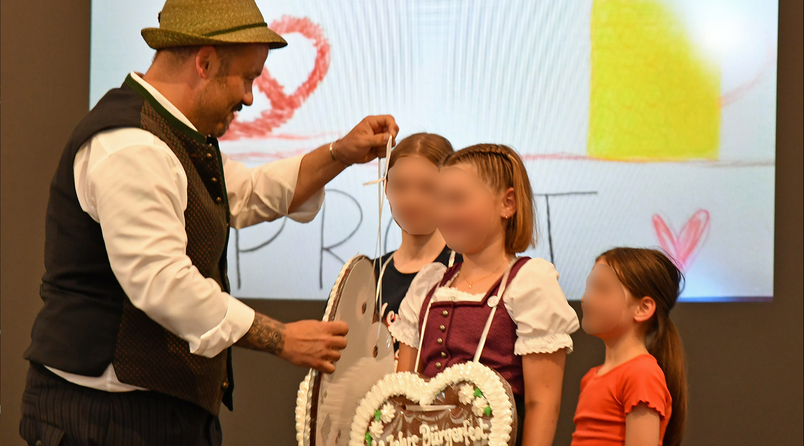 Erster Bürgermeister Florian Klietsch überreicht drei Kindern jeweils ein Lebkuchenherz.